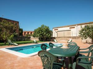 een tafel en stoelen naast een zwembad bij Belvilla by OYO Can Bertu in Sant Pere Pescador