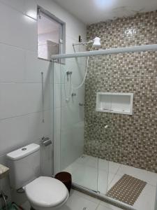 een badkamer met toilet en glazen douche bij Casa com piscina in Búzios