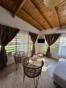 a bedroom with a bed and chairs and windows at Hospedaje LH Quinta 4 in Ezeiza