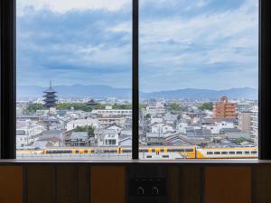 a view of a city from a window with a train at Loisir Hotel Kyoto Toji in Kyoto