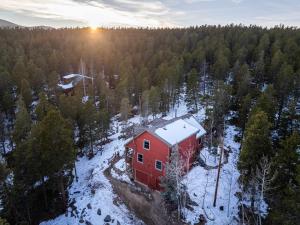 an aerial view of a red house in the snow at Arapaho Forest Lodge w Hot Tub + Trail Access in Nederland