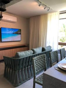 a dining room with a table and chairs and a television at Recanto dos Coqueirais in São Miguel dos Milagres +110 photos
