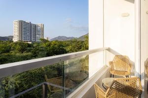 un balcon avec des chaises et une vue sur une ville dans l'établissement Increible Apartasuit a solo 3 min de la playa, à Santa Marta
