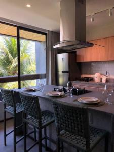 a kitchen with a table with chairs and a counter top at Recanto dos Coqueirais in São Miguel dos Milagres