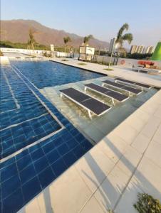 - une piscine revêtue de carrelage bleu dans l'établissement Increible Apartasuit a solo 3 min de la playa, à Santa Marta