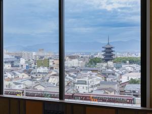a view of a city from a window with a train at Loisir Hotel Kyoto Toji in Kyoto
