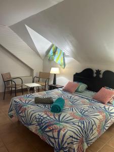 a bedroom with a bed with a colorful comforter at Appart T3 VILLAGE VACANCES SAINTE-ANNE in Courcelles Sucrerie