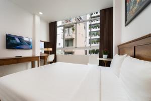 Postel nebo postele na pokoji v ubytování Saigon Park Hotel Dist 1