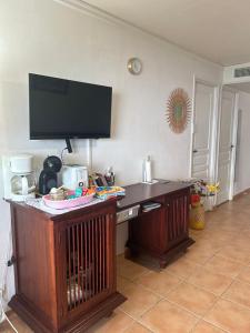 a wooden desk with a television on top of it at Appart T3 VILLAGE VACANCES SAINTE-ANNE in Courcelles Sucrerie +28 photos