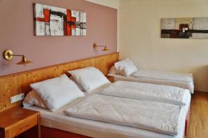 two beds in a hotel room with white sheets at Gasthof zur Strass in Eugendorf