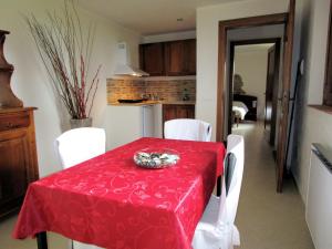 comedor con mesa roja y sillas blancas en Belvilla by OYO Quattro Orcia, en Celle sul Rigo