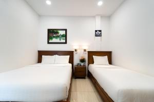 Postel nebo postele na pokoji v ubytování Saigon Park Hotel Dist 1