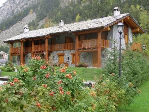 ein großes Holzhaus mit Balkon im Hof in der Unterkunft Chalet village situated in a quiet area in Antey-Saint-André