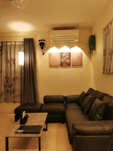 un salon avec un canapé en cuir et une table dans l'établissement UniveDo ユニブ堂, à Osaka