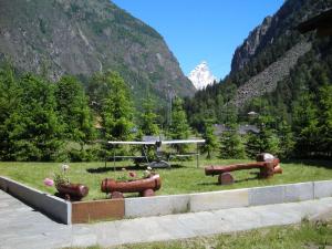 a field with sculptures in the grass in front of a mountain at Belvilla by OYO GrBe Trilo in Antey-Saint-André