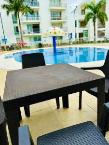 a table with an umbrella next to a swimming pool at Aqualina Green in Girardot