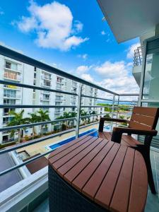 a balcony with a wooden table and chair on a building at Aqualina Green in Girardot