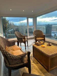 a living room with furniture and a large window at Alta vista in El Calafate