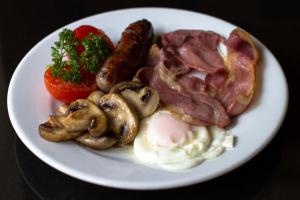 a plate of food with sausage mushrooms and a tomato at Jeakes House in Rye
