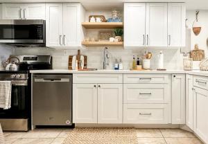 a kitchen with white cabinets and stainless steel appliances at Your Happy Place ON THE BEACH! in Key Colony Beach