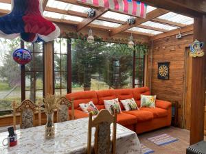 a living room with an orange couch and a table at Tribal house in Río Seco