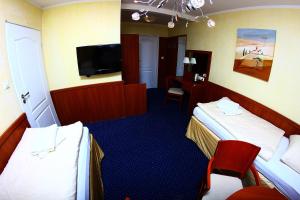 a hotel room with two beds and a flat screen tv at Kardamon in Żary