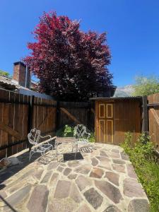 twee stoelen op een terras met een hek bij Departamento Céntrico 4 in El Bolsón