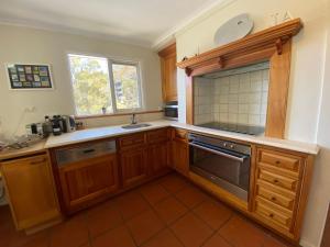 スレッドボにあるInala 3 - Thredboの木製のキャビネットとシンクと窓のあるキッチン