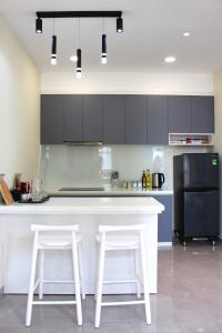 a kitchen with a white counter and a refrigerator at Kacy Homestay, Wonderland Hồ Tràm miễn phí vé MUSEUM in Xuyên Mộc