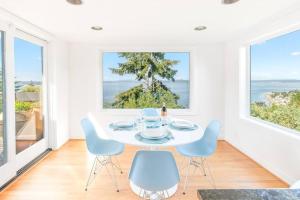 a white dining room with a table and chairs at Quintessential Seattle Water Views w HotTub in Seattle