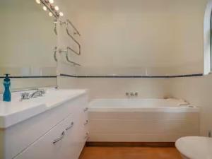 Un baño con bañera, lavabo e inodoro. en Hosts on the Coast Holiday on Hannan, en Whitianga
