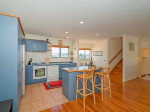 una cocina con encimeras y sillas azules y blancas en Hosts on the Coast Holiday on Hannan, en Whitianga