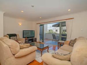 Una sala de estar con dos sofás y un televisor. en Hosts on the Coast Holiday on Hannan, en Whitianga 1 foto más