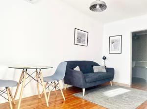 un salon avec un canapé bleu et une table dans l'établissement Al- Hamma Suites II - 2nd floor, à Lisbonne 13 autres photos