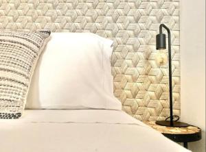 un lit avec un oreiller blanc et une lampe dans l'établissement Al- Hamma Suites II - 2nd floor, à Lisbonne