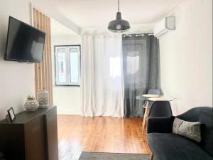 un salon avec un canapé et une télévision dans l'établissement Al- Hamma Suites II - 2nd floor, à Lisbonne