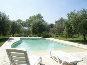 een zwembad met twee ligstoelen en een paar bij Beautiful holiday home with pool in Autignac