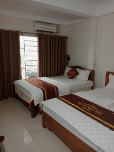 une chambre d'hôtel avec deux lits et une fenêtre dans l'établissement Minh Thành Hotel Hà Đông HN - by BAY LUXURY, à Dại Mõ