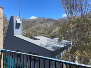 a house with a balcony with a mountain in the background at Warrina 11 - Thredbo in Thredbo