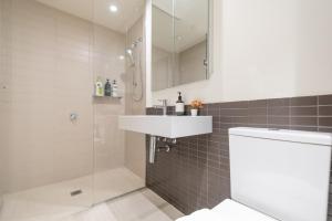 un bagno con doccia, lavandino e WC di Immaculate 1br Apt In Docklands Pool Free Parking a Melbourne