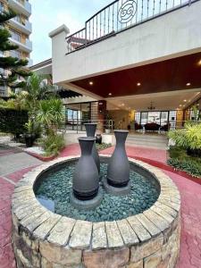 达沃市Family Suite Furnished Facing Pool的两瓶花坐在一座建筑物的喷泉里 更多14张照片