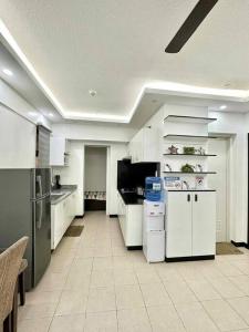 达沃市Family Suite Furnished Facing Pool的一间大厨房,配有白色橱柜和电器