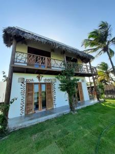 a house with a balcony and a yard at Villa Yvytu - Praia do Preá in Prea