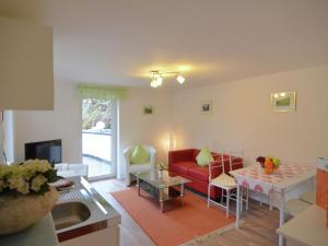 een woonkamer met een rode bank en een tafel bij Beautiful holiday home near the ski area in Schmallenberg