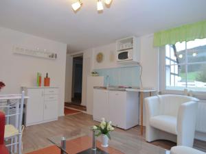 cocina y sala de estar con armarios blancos y mesa en Beautiful holiday home near the ski area, en Schmallenberg