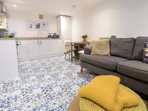 a living room with a couch and a kitchen at Eider Cottage in Buckie