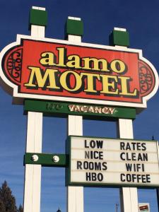 a large sign for a llama motel with signs at Alamo Motel in Sheridan