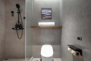 Un baño con inodoro y ducha de cristal. en Atour Hotel Hangzhou Sijiqing Qingling Road Metro Station, en Hangzhou