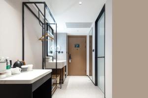 un baño con lavabo y espejo en Atour Hotel Hangzhou Sijiqing Qingling Road Metro Station, en Hangzhou