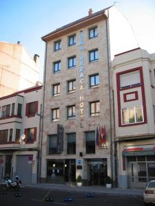 un edificio de ladrillo alto con un cartel. en Hotel Doña Urraca en Zamora